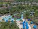 Aerial view of a neighborhood lazy river pool area surrounded by lush landscaping at 5172 Oakbourne Ave, Davenport, FL 33837