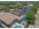 Aerial view of a neighborhood featuring homes with swimming pools and solar panels at 5172 Oakbourne Ave, Davenport, FL 33837