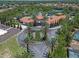 Aerial view of the community entrance with a circular driveway, lush landscaping, and surrounding neighborhood at 5172 Oakbourne Ave, Davenport, FL 33837