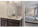 Bathroom featuring a double sink vanity, large mirror, and a glimpse into the bedroom at 5172 Oakbourne Ave, Davenport, FL 33837