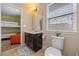 Bathroom with a single sink vanity, toilet, and view into a bedroom with bunkbeds at 5172 Oakbourne Ave, Davenport, FL 33837