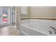 Bathroom with a large tub and separate shower featuring mosaic tiles at 5172 Oakbourne Ave, Davenport, FL 33837