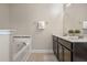 Bright bathroom with double sinks, vanity, tiled floors and a soaking tub at 5172 Oakbourne Ave, Davenport, FL 33837