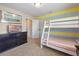 Bedroom with bunk beds, blue and yellow striped walls, and a television on a dresser at 5172 Oakbourne Ave, Davenport, FL 33837