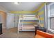 Bedroom features bunkbeds, striped accent wall, and an orange arm chair at 5172 Oakbourne Ave, Davenport, FL 33837