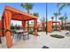 Community pool cabanas with a table and chairs for relaxing, with a playground in the background at 5172 Oakbourne Ave, Davenport, FL 33837