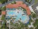 Aerial view of a large community pool area, complete with palm trees, lounge chairs, and umbrellas at 5172 Oakbourne Ave, Davenport, FL 33837