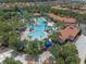 Aerial view of community pool, featuring a large pool area with palm trees and lounge chairs at 5172 Oakbourne Ave, Davenport, FL 33837
