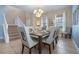 Elegant dining room featuring a chandelier, large table with seating for ten, and natural light from the windows at 5172 Oakbourne Ave, Davenport, FL 33837