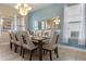 Dining room featuring blue walls, neutral toned furniture, and elegant décor with an abundance of natural light at 5172 Oakbourne Ave, Davenport, FL 33837