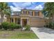 Charming two-story home with a well-manicured lawn, a two car garage, and mature landscaping at 5172 Oakbourne Ave, Davenport, FL 33837