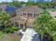 Aerial view of this two-story home featuring mature landscaping, and a two car garage at 5172 Oakbourne Ave, Davenport, FL 33837