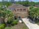 Two-story home featuring a tile roof, palm trees, and a well-maintained lawn at 5172 Oakbourne Ave, Davenport, FL 33837
