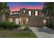 Charming two-story home featuring a well-maintained lawn, a two-car garage, and beautiful palm trees at 5172 Oakbourne Ave, Davenport, FL 33837