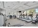 Well-equipped gym with treadmills and weight machines, featuring large windows with a pool view at 5172 Oakbourne Ave, Davenport, FL 33837