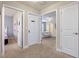 Hallway featuring doorways leading to bedrooms with neutral carpet and white paneled doors at 5172 Oakbourne Ave, Davenport, FL 33837