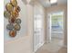 Hallway featuring decorative plates on the wall and a doorway leading into a bedroom at 5172 Oakbourne Ave, Davenport, FL 33837