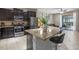 Modern kitchen with stainless steel appliances, granite countertops, dark cabinetry, and a view into the living area at 5172 Oakbourne Ave, Davenport, FL 33837