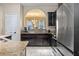 Modern kitchen featuring stainless steel appliances, dark cabinetry and tile flooring at 5172 Oakbourne Ave, Davenport, FL 33837