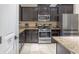 Well-equipped kitchen featuring stainless steel appliances, granite countertops, and ample cabinet space for storage at 5172 Oakbourne Ave, Davenport, FL 33837