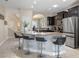 Open kitchen featuring a breakfast bar, dark cabinets, stainless steel appliances, and ample counter space at 5172 Oakbourne Ave, Davenport, FL 33837