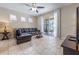 Cozy living room with a dark leather sofa, tile flooring, and sliding glass doors leading to a screened patio at 5172 Oakbourne Ave, Davenport, FL 33837