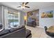 Comfortable living room featuring a leather sofa, ceiling fan, stylish wood accent wall, and sliding glass door to the pool at 5172 Oakbourne Ave, Davenport, FL 33837