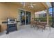 Covered patio area featuring a grill and dining table, perfect for outdoor entertaining at 5172 Oakbourne Ave, Davenport, FL 33837