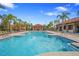 Community pool with an outdoor pavilion and several palm trees on a sunny day at 5172 Oakbourne Ave, Davenport, FL 33837