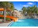 A community pool features a fun water slide surrounded by palm trees on a beautiful day at 5172 Oakbourne Ave, Davenport, FL 33837