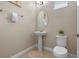 Powder room with pedestal sink, oval mirror and decorative art at 5172 Oakbourne Ave, Davenport, FL 33837