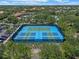 Tennis courts and pickleball courts with blue surfaces, surrounded by trees at 5172 Oakbourne Ave, Davenport, FL 33837