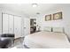 A well-lit bedroom with closet and doorway, featuring a queen bed and a sleek leather chair at 5430 Nw 55Th Pl, Ocala, FL 34482