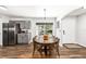 Dining area featuring a large wood table, gray cabinets, stainless steel appliances, and ample natural light at 5430 Nw 55Th Pl, Ocala, FL 34482