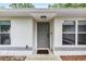 Inviting front entrance featuring a modern gray door, freshly painted trim, and convenient digital lock at 5430 Nw 55Th Pl, Ocala, FL 34482