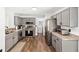 Well-lit kitchen with stainless steel appliances and gray cabinetry and wood flooring at 5430 Nw 55Th Pl, Ocala, FL 34482