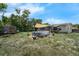 The backyard includes a pool, lawn, trees, and a shaded porch with a cover overhead at 565 S Floyd Cir, Deltona, FL 32725