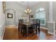 Dining room featuring elegant chandelier, wood floors, and natural light from the window at 5740 Aloma Woods Blvd, Oviedo, FL 32765