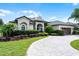 Well-maintained home with manicured lawn, paver driveway, and lush landscaping at 5740 Aloma Woods Blvd, Oviedo, FL 32765