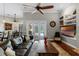 Living room boasts ceiling fans, wood floors, a comfortable leather sofa, and access to the outdoor lanai at 5740 Aloma Woods Blvd, Oviedo, FL 32765