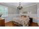 Cozy main bedroom features natural lighting, wood floors, wainscoting, and neutral tones at 5740 Aloma Woods Blvd, Oviedo, FL 32765