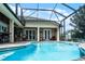 Inviting screened-in pool with brick patio and covered outdoor seating area, perfect for relaxing and entertaining at 5740 Aloma Woods Blvd, Oviedo, FL 32765