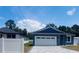 Charming home exterior with a well-manicured lawn and a gray-tiled driveway leading to a two-car garage at 63 W 10Th St, Apopka, FL 32703