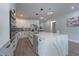 Bright, open kitchen with white cabinetry, stainless steel appliances, and a large marble island with modern pendant lighting at 63 W 10Th St, Apopka, FL 32703