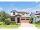 Charming two-story home featuring stone accents, a paved driveway, and a well-manicured lawn at 6925 Trellis Vine Loop, Windermere, FL 34786