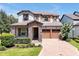 Charming two-story home with stone accents, three-car garage, and brick paver driveway at 6925 Trellis Vine Loop, Windermere, FL 34786