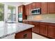 Open kitchen featuring granite countertops, stainless steel microwave, and cabinetry at 6925 Trellis Vine Loop, Windermere, FL 34786