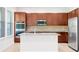 Modern kitchen featuring an island, stainless steel appliances, and granite countertops with ample cabinet space at 6925 Trellis Vine Loop, Windermere, FL 34786