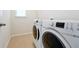 Laundry room featuring a washer and dryer, tiled floors, and natural light at 6925 Trellis Vine Loop, Windermere, FL 34786