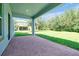 Covered patio with brick pavers overlooking the expansive backyard and lush landscaping at 6925 Trellis Vine Loop, Windermere, FL 34786